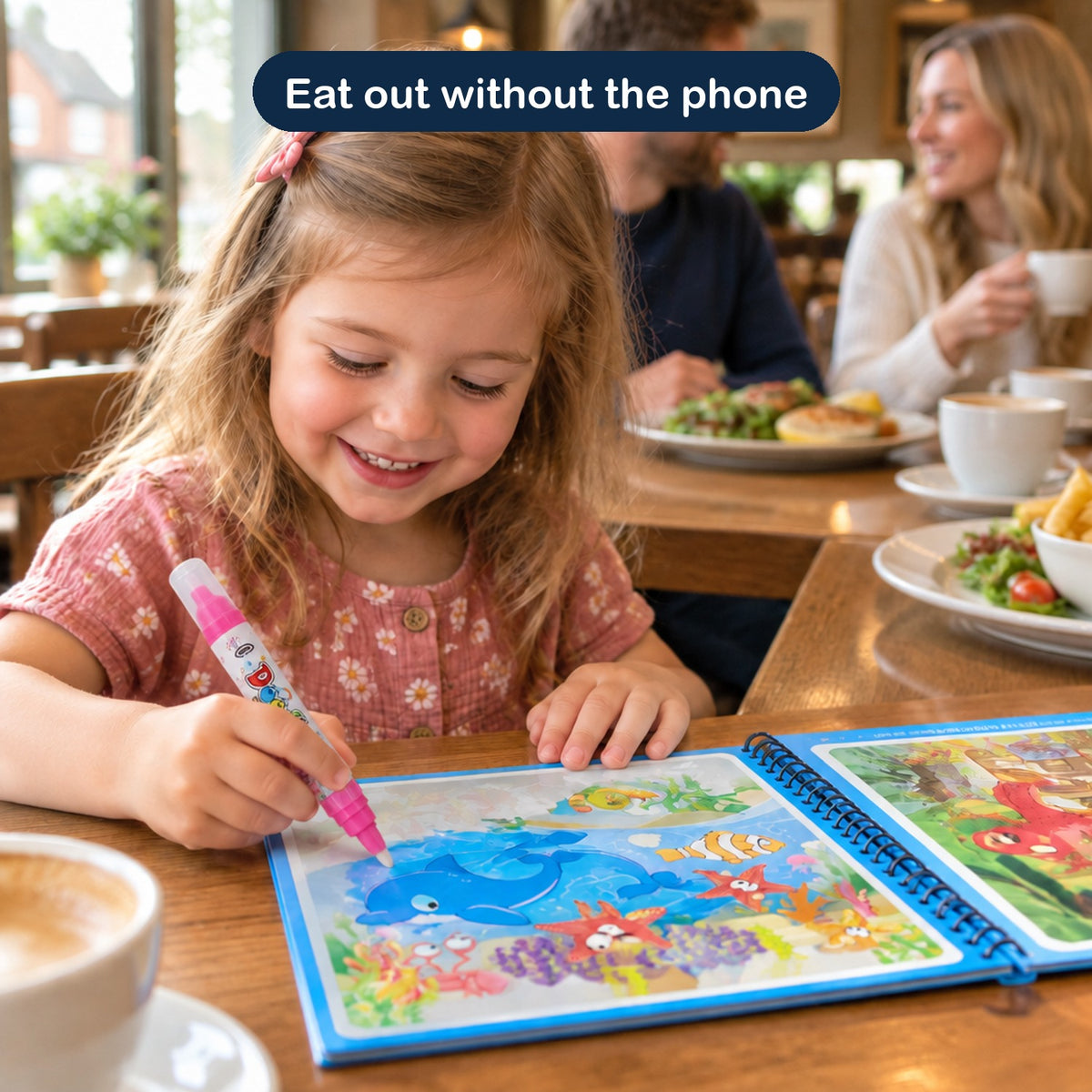 A girl colouring at a restaurant while her parents eat
